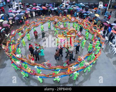 (190217) -- HANGZHOU, 17 febbraio 2019 (Xinhua) -- la foto aerea mostra i membri di una squadra di danza femminile rurale che esegue la danza del drago su panchina di legno per celebrare l'imminente Festival delle Lanterne cinesi, che cade il 19 febbraio di quest'anno, al villaggio Yaokou della città di Huyuan a Hangzhou, capitale della provincia dello Zhejiang della Cina orientale, il 17 febbraio 2019. Il villaggio di Yaokou è famoso per la sua danza drago con panchina in legno, che ha origine dalla dinastia Qing (1644-1911). Il drago a panchina in legno è lungo 130 metri con 58 panchine in legno collegate tra loro, su cui sono installate varie decorazioni a lanterna. Peopl Foto Stock