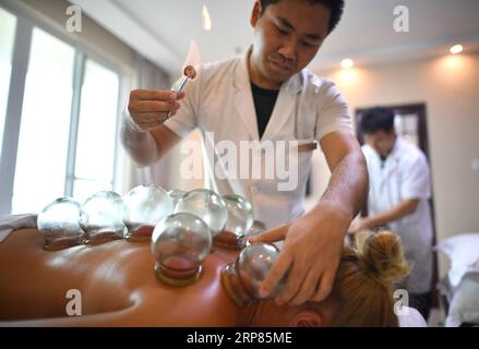 (190219) -- PECHINO, 19 febbraio 2019 (Xinhua) -- Un turista russo riceve un trattamento di coppettazione in un sanatorio a Sanya, nella provincia di Hainan nel sud della Cina, 2 giugno 2018. L'assistenza sanitaria ha continuato ad attrarre investimenti in Cina, con i fondi che fluiscono nel settore aumentando il 78,64% su base annua a 82,6 miliardi di yuan (12,28 miliardi di dollari USA) nel 2018, il China Daily ha riferito martedì. Anche se gran parte degli investimenti è stato alimentato dalle crescenti richieste sanitarie dell'invecchiamento della popolazione del paese, è stato anche aiutato dalla crescente domanda sanitaria e dal sostegno politico delle persone, il giornale ha citato un industr Foto Stock