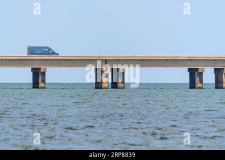 METAIRIE, LOUISIANA, USA - 12 AGOSTO 2023: Vista laterale di un furgone amazzonico che si dirige verso nord sul Lake Pontchartrain Causeway Foto Stock