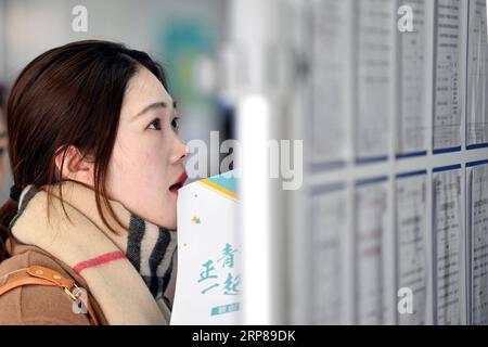 (190223) -- PECHINO, 23 febbraio 2019 (Xinhua) -- Una donna in cerca di lavoro legge informazioni sul reclutamento in una fiera del lavoro a Jinan, nella provincia dello Shandong, nella Cina orientale, 22 febbraio 2019. La Cina ha vietato le pratiche di discriminazione di genere nel reclutamento per aumentare le opportunità di carriera per le donne. Nessun requisito di genere dovrebbe essere incluso in alcun piano di reclutamento o colloqui, secondo un documento rilasciato dal Ministero delle risorse umane e della sicurezza sociale e da altre otto agenzie governative. È anche vietato chiedere informazioni sullo stato civile o di fertilità delle donne candidate durante i colloqui e la gravidanza Foto Stock