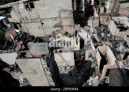 (190223) -- MANDALUYONG CITY, 23 febbraio 2019 -- i residenti cercano materiali riutilizzabili dalle loro case carbonizzate dopo un incendio in una zona slum nella città di Mandaluyong, Filippine, 23 febbraio 2019. Secondo il Philippine Bureau of Fire Protection, circa 300 baraccopoli sono stati rastrellati nell'incendio, lasciando circa 1.000 famiglie colpite mentre cinque persone sono state ferite. ) FILIPPINE-MANDALUYONG CITY-FIRE ROUELLExUMALI PUBLICATIONxNOTxINxCHN Foto Stock