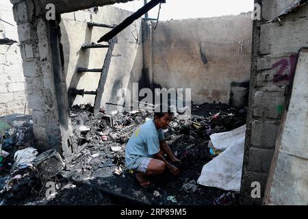 (190223) -- MANDALUYONG CITY, 23 febbraio 2019 -- Un residente cerca materiali riutilizzabili dalla sua casa carbonizzata dopo un incendio in una zona slum a Mandaluyong City, Filippine, 23 febbraio 2019. Secondo il Philippine Bureau of Fire Protection, circa 300 baraccopoli sono stati rastrellati nell'incendio, lasciando circa 1.000 famiglie colpite mentre cinque persone sono state ferite. ) FILIPPINE-MANDALUYONG CITY-FIRE ROUELLExUMALI PUBLICATIONxNOTxINxCHN Foto Stock