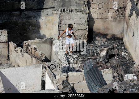 (190223) -- MANDALUYONG CITY, 23 febbraio 2019 -- Un ragazzo cerca materiali riutilizzabili dalla sua casa carbonizzata dopo un incendio in una zona slum a Mandaluyong City, Filippine, 23 febbraio 2019. Secondo il Philippine Bureau of Fire Protection, circa 300 baraccopoli sono stati rastrellati nell'incendio, lasciando circa 1.000 famiglie colpite mentre cinque persone sono state ferite. ) FILIPPINE-MANDALUYONG CITY-FIRE ROUELLExUMALI PUBLICATIONxNOTxINxCHN Foto Stock