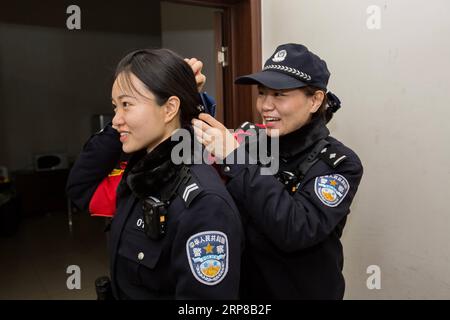 (190225) -- SHIJIAZHUANG, 25 febbraio 2019 -- Zhang Zi (R) aiuta Wang lei con i capelli prima di andare a lavorare a Shijiazhuang, nella provincia di Hebei, nella Cina settentrionale, il 23 febbraio 2019. Durante la corsa di quest'anno al Festival di Primavera, Zhang Zi, un ufficiale di polizia ferroviaria di 32 anni, ha lavorato insieme al suo apprendista Wang lei, un ufficiale di 24 anni. Sono stati impegnati ad aiutare i passeggeri, a gestire le emergenze e a mantenere l'ordine alla stazione ferroviaria di Shijiazhuang. Questa è la seconda volta che la coppia lavora insieme durante la corsa di viaggio del Festival di Primavera. ) CHINA-SHIJIAZHUANG-POLICE-APPRENTICE (CN) MU Foto Stock