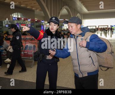 (190225) -- SHIJIAZHUANG, 25 febbraio 2019 -- Wang lei (fronte L) aiuta un passeggero alla stazione ferroviaria di Shijiazhuang nella provincia di Hebei nella Cina settentrionale, il 23 febbraio 2019. Durante la corsa di quest'anno al Festival di Primavera, Zhang Zi, un ufficiale di polizia ferroviaria di 32 anni, ha lavorato insieme al suo apprendista Wang lei, un ufficiale di 24 anni. Sono stati impegnati ad aiutare i passeggeri, a gestire le emergenze e a mantenere l'ordine alla stazione ferroviaria di Shijiazhuang. Questa è la seconda volta che la coppia lavora insieme durante la corsa di viaggio del Festival di Primavera. ) CHINA-SHIJIAZHUANG-POLICE-APPRENTICE (CN) MUXYU PUBL Foto Stock