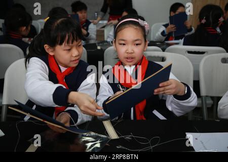 (190226) -- PECHINO, 26 febbraio 2019 (Xinhua) -- gli studenti realizzano libri cinesi legati a fili durante un'esperienza culturale tradizionale a Rong Bao Zhai, un rinomato editore di stampe in legno, nella via Qianmen a Pechino, capitale della Cina, 26 febbraio 2019. (Xinhua/Zhu Bo) CHINA-BEIJING-TRADITIONAL CULTURE (CN) PUBLICATIONxNOTxINxCHN Foto Stock