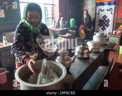 (190227) -- LHASA, Feb. 27, 2019 (Xinhua) -- Una pastorizia scioglie il ghiaccio prima di bollire l'acqua nel Garco Township della contea di Shuanghu, regione autonoma Tibet della Cina sud-occidentale, 31 gennaio 2019. La contea di Shuanghu, situata a 5.000 metri sul livello del mare nella regione autonoma del Tibet nella Cina sud-occidentale, soffre di forti venti 200 giorni all'anno. Con una temperatura media di cinque gradi Celsius per tutto l'anno, Shuanghu ospita il terzo ghiacciaio più grande del mondo, il Purog Kangri. Occasionalmente, la temperatura qui scende a meno 40 gradi Celsius. La contea, circa 120.000 chilometri quadrati di area, si trova io Foto Stock