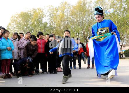 (190227) -- PECHINO, 27 febbraio 2019 (Xinhua) -- Un trouper di Kehaiqiang interagisce con gli alunni della Lijiazhuang Primary School a Jinzhou, città di Shijiazhuang, capitale della provincia di Hebei nella Cina settentrionale, 28 novembre 2018. Kehaiqiang , dramma locale originato da ballate, è stato elencato come patrimonio culturale immateriale di Shijiazhuang nel 2013. Il 19° Congresso Nazionale del Partito Comunista Cinese (CPC), convocato nell'ottobre 2017, per la prima volta propose di perseguire una strategia di rivitalizzazione rurale e chiarì che lo sviluppo dell'agricoltura e delle aree rurali doveva essere prioritario. Revita Foto Stock