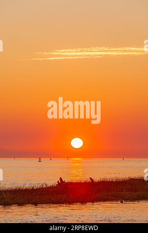 Il sole tramonta sull'isola di Vancouver visto da Steveston, nella Columbia Britannica, Canada Foto Stock