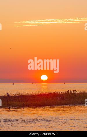 Il sole tramonta sull'isola di Vancouver visto da Steveston, nella Columbia Britannica, Canada Foto Stock