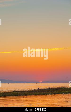 Il sole tramonta sull'isola di Vancouver visto da Steveston, nella Columbia Britannica, Canada Foto Stock