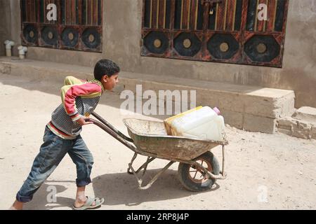 (190307) -- SANAA, 7 marzo 2019 -- Un ragazzo yemenita spinge una carriola con contenitori di plastica riempiti di acqua potabile da un serbatoio d'acqua donato durante la crisi idrica in corso a Sanaa, Yemen, il 7 marzo 2019. Lo Yemen ha sofferto di una grave crisi idrica dopo quattro anni di guerra civile mortale. Secondo le Nazioni Unite, oltre 18 milioni di yemeniti attualmente non hanno accesso all'acqua potabile pulita. ) YEMEN-SANAA-ACQUA POTABILE-CRISI Mohamedxal-Azaki PUBLICATIONxNOTxINxCHN Foto Stock