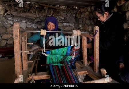 (190309) -- LHASA, 9 marzo 2019 (Xinhua) -- Ji Qiumei (R) parla con un membro di una famiglia di pastori nella regione autonoma del Tibet del sud-ovest della Cina, 26 febbraio 2019. Tagliare le fette da un gigot mentre chiacchierate con i pastori locali nel fluente tibetano, Ji Qiumei, sottili e con occhiali, si adatta perfettamente alla prateria. Nato nel 1965, Ji ha studiato yak tibetani per 30 anni. In questo campo, è l'unica ricercatrice femminile e l'unica con un dottorato. Con l'obiettivo di aiutare i pastori ad uscire dalla povertà attraverso la sua ricerca, Ji vede le praterie e i pascoli come i suoi laboratori. Negli ultimi anni, lei Foto Stock