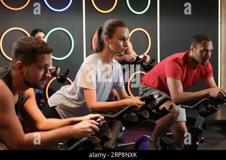 Gruppo di persone che si allenano sulle cyclette nel fitness club Foto Stock