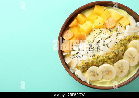 Gustoso frullato con frutta fresca su sfondo turchese, vista dall'alto. Spazio per il testo Foto Stock