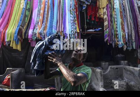 (190314) -- PECHINO, 14 marzo 2019 () -- Un uomo porta vestiti in una lavanderia all'aperto, conosciuta localmente come dhobi ghat , a Mumbai, India, 13 marzo 2019. Le lavanderie all'aperto della città hanno una storia di oltre 100 anni. (/Stringer) FOTO DEL GIORNO Xinhua PUBLICATIONxNOTxINxCHN Foto Stock