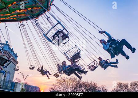 (190325) -- PECHINO, 25 marzo 2019 -- le persone fanno un giro sulla giostra Luftikus swing nel parco divertimenti Prater di Vienna, Austria, il 24 marzo 2019. ) XINHUA FOTO DEL GIORNO GuoxChen PUBLICATIONxNOTxINxCHN Foto Stock