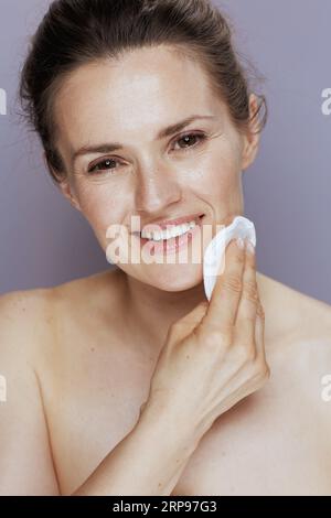 donna moderna sorridente con imbottitura in cotone su sfondo blu. Foto Stock
