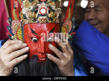 (190330) -- PECHINO, 30 marzo 2019 (Xinhua) -- Un artista popolare indossa una maschera dell'opera Dixi nel villaggio di Zhouguan del distretto di Xixiu ad Anshun, nella provincia di Guizhou nella Cina sud-occidentale, 28 marzo 2019. Dixi, un'opera locale ad Anshun, è stata elencata come uno dei patrimoni culturali immateriali nazionali nel 2006. Nel villaggio di Zhouguan, c'è una troupe Dixi con membri da adolescenti a octogenari. Lo spettacolo della compagnia secolare è popolare tra gli abitanti del villaggio. I membri della troupe di solito discutono l'abilità di fare la maschera di Dixi e la performance nella stagione della coltivazione lenta. (Xinhua/Yang Wenbin) Foto Stock