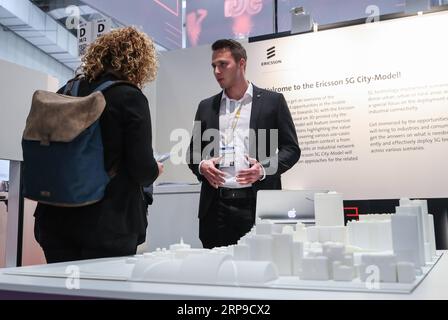 (190403) -- HANNOVER, 3 aprile 2019 (Xinhua) -- Un membro dello staff introduce l'applicazione della rete 5G a un visitatore della 5G Arena durante la fiera di Hannover 2019 ad Hannover, Germania, 1 aprile 2019. (Xinhua/Shan Yuqi) GERMANIA-HANNOVER FAIR-RETE 5G PUBLICATIONxNOTxINxCHN Foto Stock