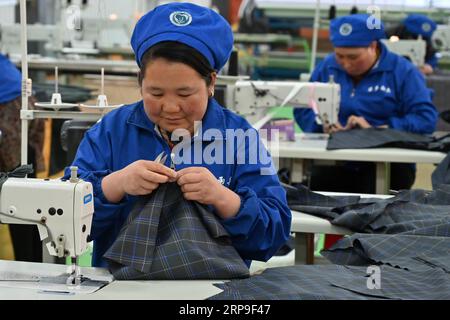 (190405) -- DONGXIANG, 5 aprile 2019 (Xinhua) -- i lavoratori elaborano il tessuto ombrello con macchine da cucire in un laboratorio nella contea autonoma di Dongxiang, provincia del Gansu della Cina nordoccidentale, 3 aprile 2019. Dal 2018, ai laboratori di riduzione della povertà è stata data la priorità nell'accelerare la campagna di aiuto alla povertà in corso nella contea autonoma di Dongxiang, con la quale le persone colpite dalla povertà si sono guadagnate un lavoro costante per aiutare a uscire dalla povertà. Finora, sono stati istituiti 18 workshop per la riduzione della povertà, creando opportunità di lavoro per oltre 700 persone del posto, tra cui più di 500 impover registrati Foto Stock