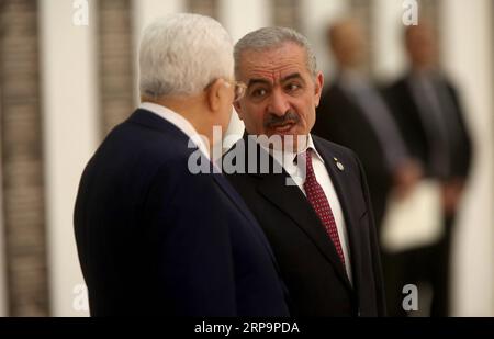 (190413) -- RAMALLAH, 13 aprile 2019 -- il nuovo primo ministro palestinese Mohammed Ishtaye (R) ha parlato con il presidente palestinese Mahmoud Abbas durante la cerimonia di giuramento del nuovo governo nella città di Ramallah in Cisgiordania, 13 aprile 2019. Il nuovo primo ministro palestinese Mohammed Ishtaye e i suoi membri del gabinetto hanno prestato giuramento sabato prima del presidente Mahmoud Abbas nella sua sede centrale nella città di Ramallah in Cisgiordania, ha riferito la televisione ufficiale. ) MIDEAST-RAMALLAH-NUOVO GOVERNO PALESTINESE-GIURAMENTO A FADIXAROURI PUBLICATIONXNOTXINXCHN Foto Stock