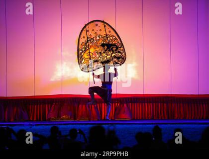 (190414) -- BANGKOK, 14 aprile 2019 (Xinhua) -- un artista esegue Nang Yai, una performance fantoccio ombra, al Wat Khanon nella provincia di Ratchaburi, Thailandia, 13 aprile 2019. Nang yai è una forma di gioco ombra che si trova in Thailandia e Cambogia. I burattini sono fatti di bufalo dipinto, mentre la storia è narrata da canzoni, canti e musica. (Xinhua/Zhang Keren) THAILANDIA-RATCHABURI-SHADOW PUBLICATIONxNOTxINxCHN Foto Stock