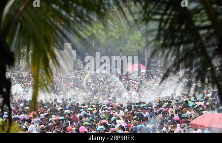 (190415) -- XISHUANGBANNA, 15 aprile 2019 -- la gente festeggia il festival della spolveratura d'acqua in una piazza nella città di Jinghong, prefettura autonoma dai di Xishuangbanna, provincia dello Yunnan della Cina sud-occidentale, 15 aprile 2019. Le persone si cospargono l'acqua l'una verso l'altra per pregare per la buona fortuna durante il tradizionale festival dell'acqua, che è anche il festival di Capodanno del gruppo etnico dai. Qin Qing) CHINA-YUNNAN-XISHUANGBANNA-WATER SPRINKLING FESTIVAL (CN) qinqing PUBLICATIONxNOTxINxCHN Foto Stock