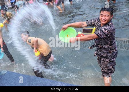 (190415) -- XISHUANGBANNA, 15 aprile 2019 (Xinhua) -- la gente celebra il festival della spolveratura d'acqua in una piazza nella città di Jinghong, prefettura autonoma dai di Xishuangbanna, provincia dello Yunnan della Cina sud-occidentale, 15 aprile 2019. Le persone si cospargono l'acqua l'una verso l'altra per pregare per la buona fortuna durante il tradizionale festival dell'acqua, che è anche il festival di Capodanno del gruppo etnico dai. (Xinhua/Zhang Yuwei) CHINA-YUNNAN-XISHUANGBANNA-WATER SPRINKLING FESTIVAL (CN) PUBLICATIONxNOTxINxCHN Foto Stock