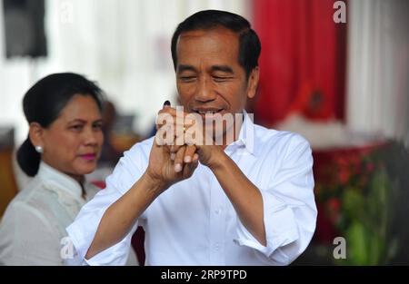 (190417) -- GIACARTA, 17 aprile 2019 -- il presidente indonesiano in carica Joko Widodo mostra il suo dito inchiostrato mentre la moglie Iriana si occupa delle elezioni dopo le elezioni in un collegio elettorale a Giacarta, in Indonesia, ad aprile. 17, 2019. Gli elettori indonesiani hanno iniziato a votare mercoledì, mentre i seggi elettorali sono stati aperti nella parte orientale del vasto paese arcipelagico per selezionare un nuovo presidente e membri del parlamento. ) INDONESIA-GIACARTA-ELEZIONI-VOTO Zulkarnain PUBLICATIONxNOTxINxCHN Foto Stock