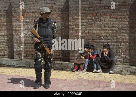 (190418) -- SRINAGAR, 18 aprile 2019 (Xinhua) -- un gruppo paramilitare indiano assiste i bambini del Kashmir durante la seconda fase delle elezioni generali in India, all'esterno di un seggio elettorale nella periferia della città di Srinagar, capitale estiva del Kashmir controllato dagli indiani, 18 aprile 2019. (Xinhua/Javed Dar) KASHMIR-SRINAGAR-ELEZIONE-SECONDA FASE PUBLICATIONxNOTxINxCHN Foto Stock