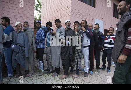 (190418) -- SRINAGAR, 18 aprile 2019 (Xinhua) -- gli elettori del Kashmir si mettono in fila per esprimere i propri voti durante la seconda fase delle elezioni generali in India, fuori da un seggio elettorale nella periferia della città di Srinagar, capitale estiva del Kashmir controllato dagli indiani, 18 aprile 2019. (Xinhua/Javed Dar) KASHMIR-SRINAGAR-ELEZIONE-SECONDA FASE PUBLICATIONxNOTxINxCHN Foto Stock