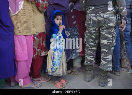 (190418) -- SRINAGAR, 18 aprile 2019 (Xinhua) -- una ragazza del Kashmir guarda mentre sua madre è in fila con altri elettori durante la seconda fase delle elezioni generali in India, fuori da un seggio elettorale nella periferia di Srinagar, la capitale estiva del Kashmir controllato dagli indiani, il 18 aprile 2019. (Xinhua/Javed Dar) KASHMIR-SRINAGAR-ELEZIONE-SECONDA FASE PUBLICATIONxNOTxINxCHN Foto Stock