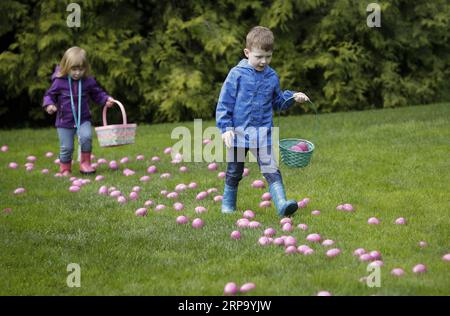 (190419) -- VANCOUVER, 19 aprile 2019 -- i bambini raccolgono le uova durante l'Eggciting Easter Hop al VanDusen Botanical Garden di Vancouver, Canada, il 19 aprile 2019. La caccia all'uovo di Pasqua ha attirato qui le famiglie il venerdì, in cui i bambini potevano raccogliere uova vicino all'area labirinto e ricevere un premio di cioccolato, e saltare a musica divertente sul prato. ) CANADA-VANCOUVER-EASTER-EGG HUNT LiangxSen PUBLICATIONxNOTxINxCHN Foto Stock