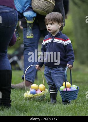 (190419) -- VANCOUVER, 19 aprile 2019 -- Un bambino trasporta cesti di uova durante l'Eggciting Easter Hop al VanDusen Botanical Garden di Vancouver, Canada, il 19 aprile 2019. La caccia all'uovo di Pasqua ha attirato qui le famiglie il venerdì, in cui i bambini potevano raccogliere uova vicino all'area labirinto e ricevere un premio di cioccolato, e saltare a musica divertente sul prato. ) CANADA-VANCOUVER-EASTER-EGG HUNT LiangxSen PUBLICATIONxNOTxINxCHN Foto Stock