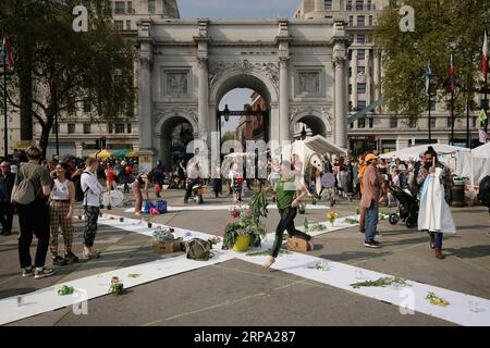 (190422) -- LONDRA, 22 aprile 2019 -- la gente poggia fiori durante la dimostrazione del cambiamento climatico al Marble Arch di Londra, in Gran Bretagna, il 22 aprile 2019. I manifestanti organizzati dalla ribellione dell'estinzione si sono riuniti qui lunedì chiedendo un'azione sul cambiamento climatico. ) REGNO UNITO-LONDRA-DIMOSTRAZIONE SUI CAMBIAMENTI CLIMATICI TimxIreland PUBLICATIONxNOTxINxCHN Foto Stock