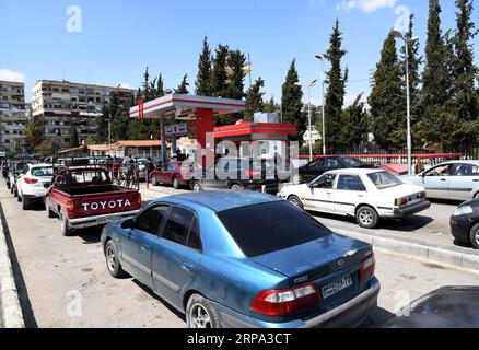 (190423) - DAMASCO, 23 aprile 2019 - i siriani si schierano per riempire le loro auto con benzina in una stazione di servizio a Damasco, Siria, il 23 aprile 2019. Decine di camion di carburante hanno raggiunto le aree governative provenienti dalla regione curda nel nord-est della Siria, in un'acuta carenza di carburante nel paese, un monitoraggio di guerra riportato martedì. La crisi del carburante è il risultato delle rinnovate sanzioni statunitensi contro la Siria, che sono state inasprite attraverso l'ultima serie di sanzioni imposte al paese nel marzo del 2019. ) SIRIA-DAMASCO-STAZIONE DI SERVIZIO-FUEL SHORTAGE AMMARXSAFARJALANI PUBLICATIONXNOTXINXCHN Foto Stock