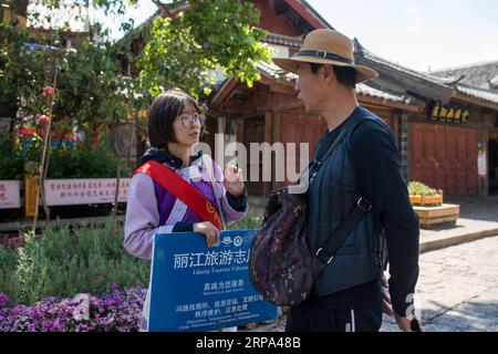 (190424) -- LIJIANG, 24 aprile 2019 (Xinhua) -- Un volontario aiuta un turista a Lijiang, nella provincia dello Yunnan della Cina sud-occidentale, 22 aprile 2019. Secondo le autorità locali, il turismo ha iniziato a scaldarsi quando è stato lanciato un servizio ferroviario più veloce tra Lijiang e la capitale provinciale Kunming all'inizio del 2019. Durante la prima stagione, Lijiang ha accolto 12,325 milioni di arrivi e ha registrato un fatturato totale di 25,637 miliardi di yuan, rispettivamente in crescita del 21,5% e del 15,13% rispetto all'anno precedente. (Xinhua/Hu Chao) CHINA-YUNNAN-LIJIANG-TOURISM (CN) PUBLICATIONxNOTxINxCHN Foto Stock