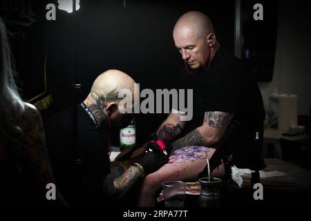 (190427) -- VARSAVIA, 27 aprile 2019 -- Un uomo è visto tatuarsi durante la quarta edizione dei Varsavia Tattoo Days a Varsavia, in Polonia, il 27 aprile 2019. ) POLONIA-VARSAVIA-TATUAGGIO JaapxArriens PUBLICATIONxNOTxINxCHN Foto Stock