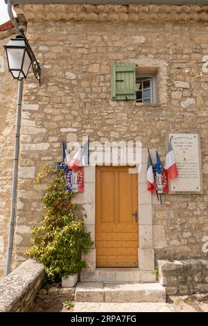 Uno splendido edificio tradizionale in pietra con una porta ad arco e finestra situato in un pittoresco villaggio francese Foto Stock