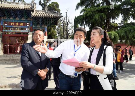 (190506) -- ZOUCHENG, 6 maggio 2019 (Xinhua) -- Meng Xing (R, fronte), discendente di 72a generazione dell'antico filosofo cinese Mencio, parla con gli ospiti che vengono per partecipare alla cerimonia di commemorazione di Mencio e della madre di Mencio al Tempio di Mencio nella città di Zoucheng, nella provincia dello Shandong della Cina orientale, 6 maggio 2019. Vivendo in una comunità vicino al Tempio di Mencio, Meng Xing, di 37 anni, è responsabile della manutenzione del Tempio di Mencio, della Mansione di Mencio e del Cimitero di Mencio. (Xinhua/Wang Kai) CHINA-SHANDONG-ZOUCHENG-MENCIUS-DESCENDANT (CN) PUBLICATIONxNOTxINxCHN Foto Stock