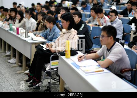 (190510) -- HARBIN, 10 maggio 2019 (Xinhua) -- Qin Tingting (2a R, prima fila) partecipa alla classe sulla sedia a rotelle a Harbin, nella provincia di Heilongjiang nella Cina nordorientale, il 9 maggio 2019. Qin Tingting, originario della regione autonoma della Mongolia interna della Cina settentrionale, è una matricola della Harbin Engineering University. Soffrendo di sindrome miastenica congenita (CMS, noto anche come debolezza muscolare), deve sedersi su una sedia a rotelle e fare molto più sforzo rispetto alle persone normali. Dopo essere stata diagnosticata con il CMS, Qin non ha mai rinunciato al suo sogno di entrare all'università. È stata ammessa al College of Foto Stock