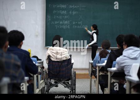 (190510) -- HARBIN, 10 maggio 2019 (Xinhua) -- Qin Tingting partecipa alla lezione sulla sedia a rotelle a Harbin, nella provincia di Heilongjiang nella Cina nordorientale, il 9 maggio 2019. Qin Tingting, originario della regione autonoma della Mongolia interna della Cina settentrionale, è una matricola della Harbin Engineering University. Soffrendo di sindrome miastenica congenita (CMS, noto anche come debolezza muscolare), deve sedersi su una sedia a rotelle e fare molto più sforzo rispetto alle persone normali. Dopo essere stata diagnosticata con il CMS, Qin non ha mai rinunciato al suo sogno di entrare all'università. È stata ammessa al College of Materials Science a Foto Stock