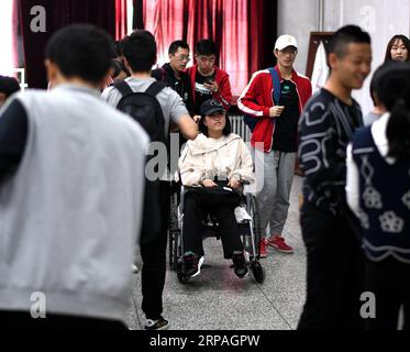 (190510) -- HARBIN, 10 maggio 2019 (Xinhua) -- Qin Tingting (C) lascia l'aula con l'aiuto dei suoi compagni di classe a Harbin, nella provincia di Heilongjiang, nel nord-est della Cina, il 9 maggio 2019. Qin Tingting, originario della regione autonoma della Mongolia interna della Cina settentrionale, è una matricola della Harbin Engineering University. Soffrendo di sindrome miastenica congenita (CMS, noto anche come debolezza muscolare), deve sedersi su una sedia a rotelle e fare molto più sforzo rispetto alle persone normali. Dopo essere stata diagnosticata con il CMS, Qin non ha mai rinunciato al suo sogno di entrare all'università. È stata ammessa al College o Foto Stock