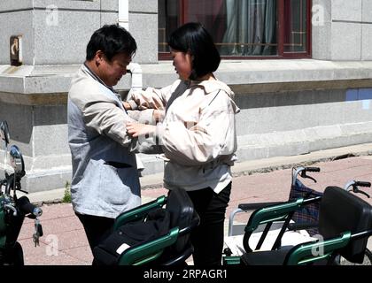 (190510) -- HARBIN, 10 maggio 2019 (Xinhua) -- Qin Shoucheng, padre di Qin Tingting, la aiuta a sedersi sulla sedia a rotelle a Harbin, nella provincia di Heilongjiang, nel nord-est della Cina, il 9 maggio 2019. Qin Tingting, originario della regione autonoma della Mongolia interna della Cina settentrionale, è una matricola della Harbin Engineering University. Soffrendo di sindrome miastenica congenita (CMS, noto anche come debolezza muscolare), deve sedersi su una sedia a rotelle e fare molto più sforzo rispetto alle persone normali. Dopo essere stata diagnosticata con il CMS, Qin non ha mai rinunciato al suo sogno di entrare all'università. E' stata ammessa al Colle Foto Stock