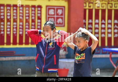 (190513) -- DAHUA, 13 maggio 2019 (Xinhua) -- due ragazzi si lavano i capelli alla Nongyong Primary School di Bansheng Township della contea autonoma di Dahua Yao, nella regione autonoma del Guangxi Zhuang, nella Cina meridionale, il 10 maggio 2019. A causa delle difficili condizioni ambientali come la desertificazione rocciosa e la forma montuosa del terreno, la contea di Dahua nel Guangxi è stata a lungo un'area meno sviluppata. Negli ultimi anni, il governo locale ha attuato molte misure per il lavoro di riduzione della povertà. Il governo aiutò la popolazione locale a costruire strade, riparare case e migliorare l'istruzione. (Xinhua/Huang Xiaobang) CINA-GUANGXI-POVERTY ALLEV Foto Stock