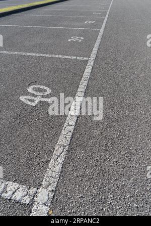 la numerazione tracciata sul marciapiede di un parcheggio Foto Stock