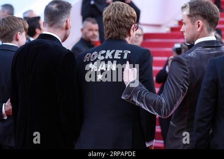 (190517) -- CANNES, 17 maggio 2019 (Xinhua) -- l'attore Taron Egerton (1st R) indica il motivo Rocketman sulla schiena del produttore Elton John sul Red carpet per la prima del film Rocketman al 72° Festival di Cannes, Francia, il 16 maggio 2019. Il 72° Festival di Cannes si svolge qui dal 14 al 25 maggio. (Xinhua/Zhang Cheng) FRANCE-CANNES-FILM ROCKETMAN -PREMIERE PUBLICATIONxNOTxINxCHN Foto Stock