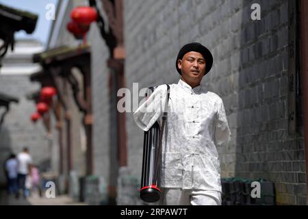 (190519) -- NANCHANG, 19 maggio 2019 (Xinhua) -- Cai Mujiang è sulla strada per eseguire la scrittura calligrafica nel distretto Xinjian di Nanchang, capitale della provincia del Jiangxi della Cina orientale, 18 maggio 2019. Cai Mujiang, trentacinque anni, è un calligrafo con una differenza. All'età di 23 anni, Cai perse le braccia in un incidente. Nonostante la tragedia, Cai si rifiutò di arrendersi e fu in grado di prendersi cura di se stesso dopo sforzi ardui. Nel 2010, Cai iniziò a imparare a usare la sua bocca per scrivere la calligrafia cinese. Dopo un anno di apprendimento, padroneggiò le abilità e si guadagnò da vivere scrivendo calligrafia nel st Foto Stock