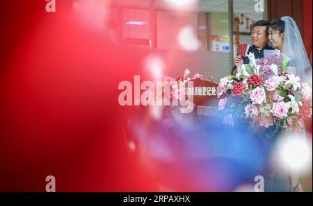 (190521) -- PECHINO, 21 maggio 2019 (Xinhua) -- Una coppia posa per una foto in un ufficio di registrazione matrimonio nel distretto di Chaoyang a Changchun, provincia di Jilin della Cina nordorientale, 20 maggio 2019. (Xinhua/Zhang Nan) XINHUA FOTO DEL GIORNO PUBLICATIONxNOTxINxCHN Foto Stock